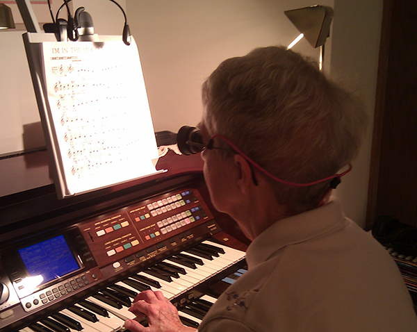 Patient reading sheet music with low vision glasses